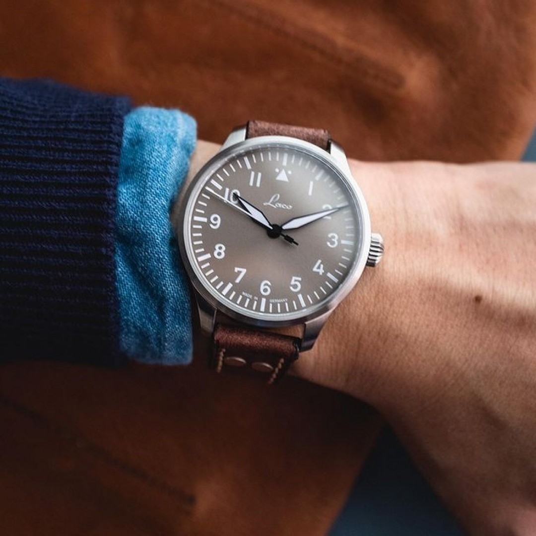 The original german pilot watch of WW2 era - of which Laco is one of the historic official suppliers - had always featured huge diameters as they were worn outside the uniform to facilitate clear readings of time. Over the years, as the iconic designs proved resilient even for modern styles, the diameters have settled around the standard 41-42mm, more or less
.
in 2020, Laco started producing the 39mm versions of these historic aviation design, just like this Ausburg Taupe 39mm model. The reduced size allow the timepiece to blend in, rather than standing out, with the overall outfit for a thoroughly harmonious look, giving this tool watch a truly sporty elegance nuance. And if you dig the sartorial taupe dial, we recommend that you preview one asap - this is a limited edition model of only 500 pieces, and for that reason will be sold out soon
.
